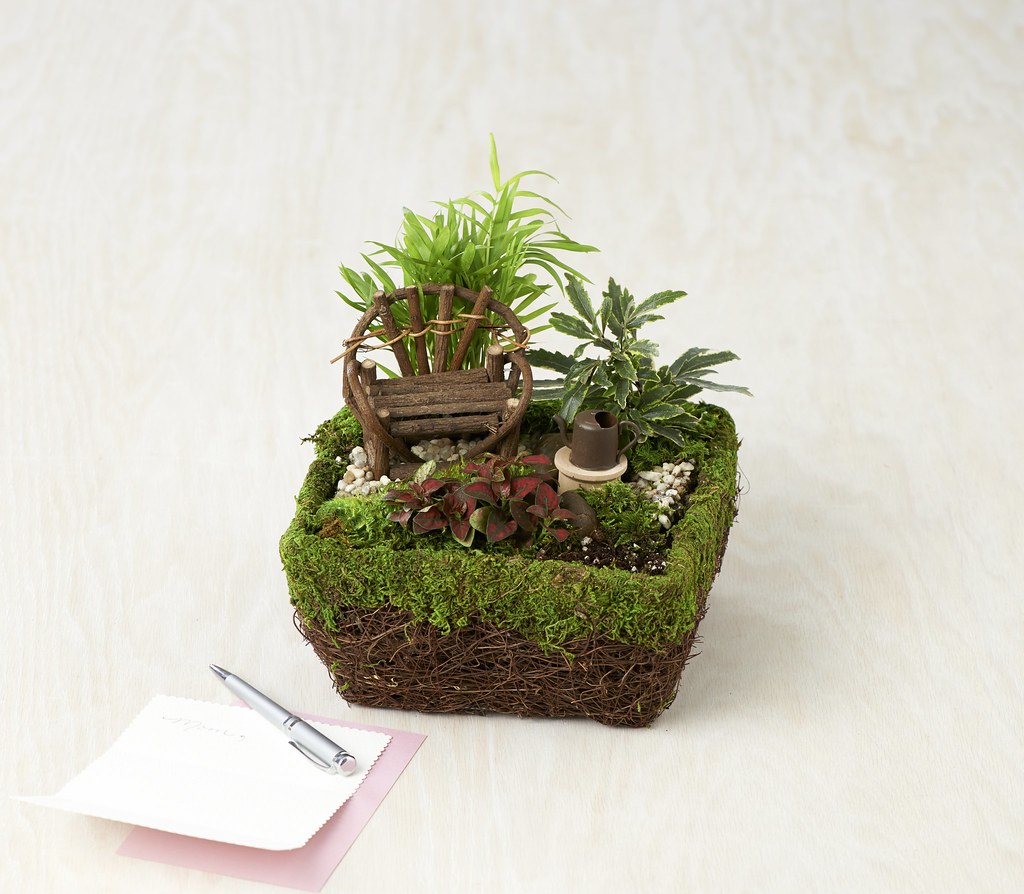 Small basket planter with greenery and a miniature watering can