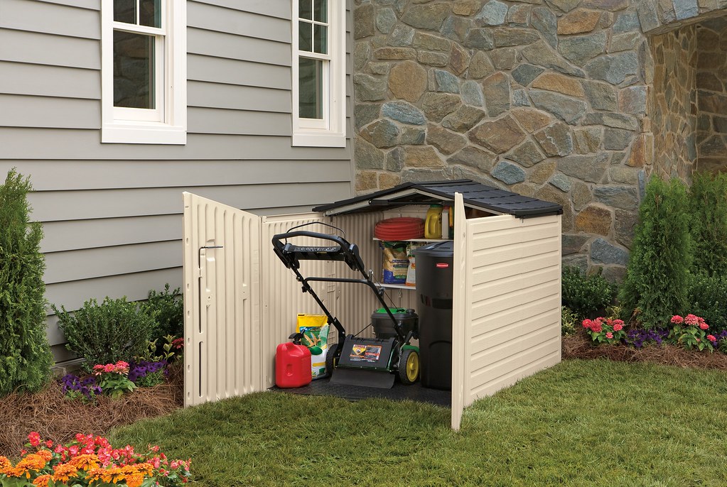 Small outdoor shed storing a lawn mower and garden supplies