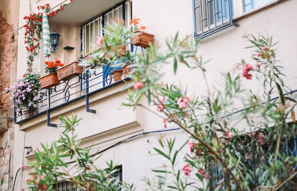 Rectangular flower boxes attached to apartment balcony railings