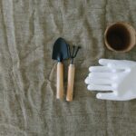 Gardening glove small trowel hand rake and seed pot on burlap