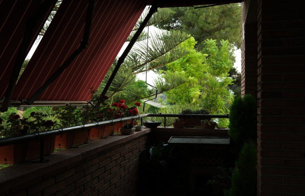 Covered balcony with potted plants and railing planters